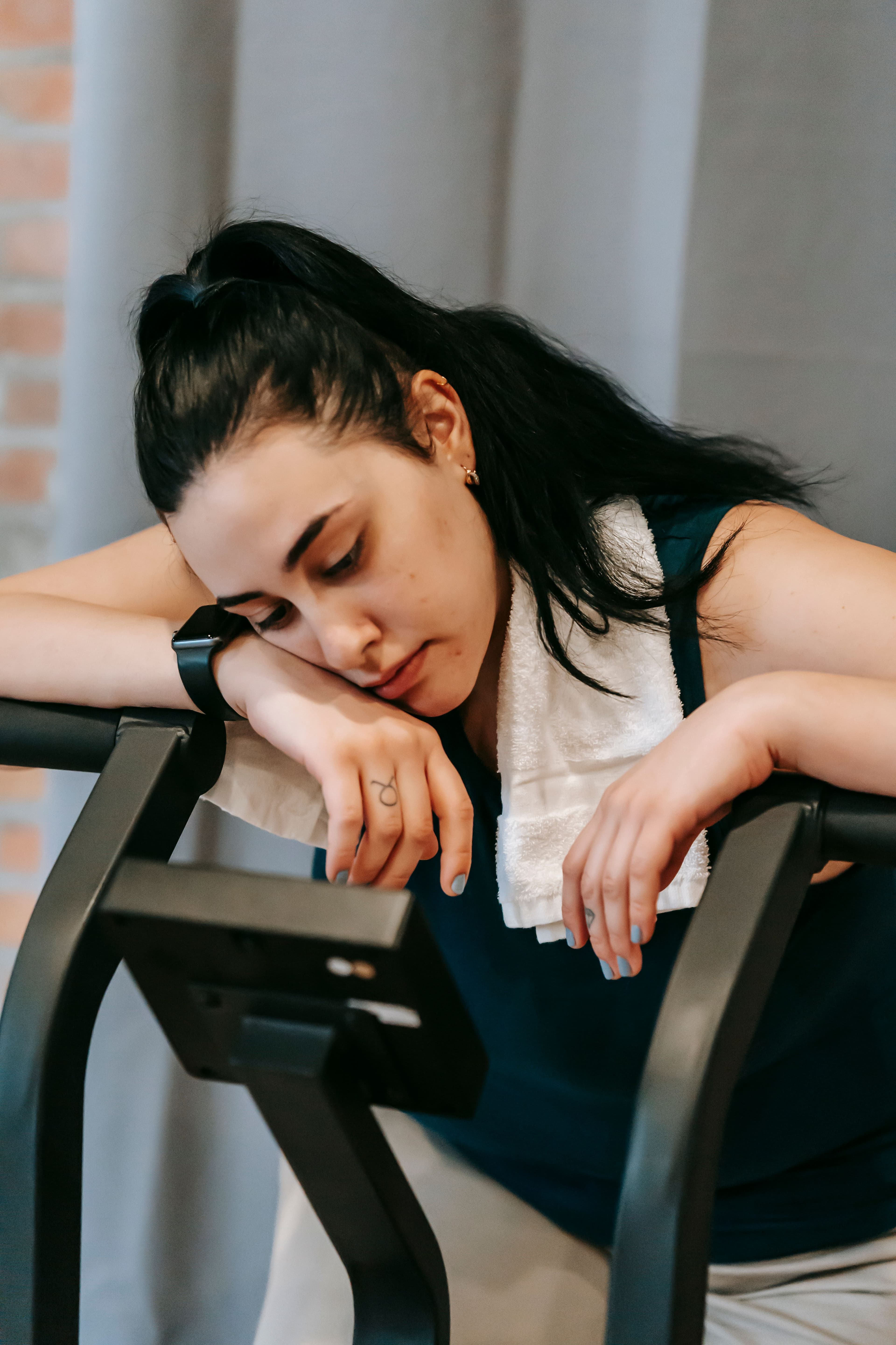 A tired person resting with a towel around their neck